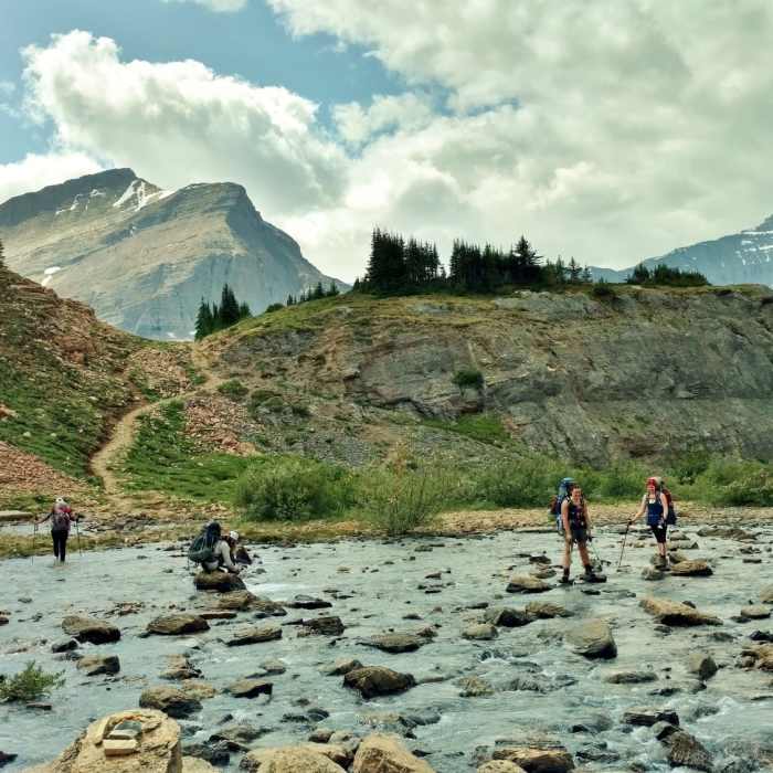 Now what? - Crossing the Brazeau River just below Nigel Pass. Two on the left take off their boots, three on the right rock hop it. Near Brazeau Loop