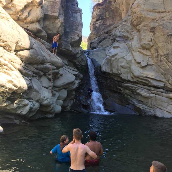 A teenager gets ready to jump off the cliff. Near Last Chance Trail
