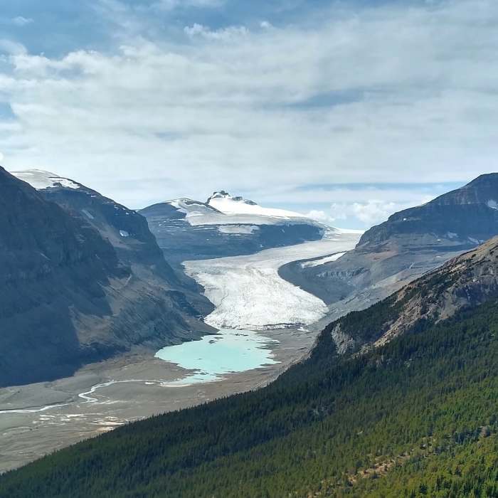 Castleguard Mountain in the distance (center) rises above Saskatchewan Glacier. Melt water from the glacier is the beginning of the North Saskatchewan River. Near Parker Ridge Trail