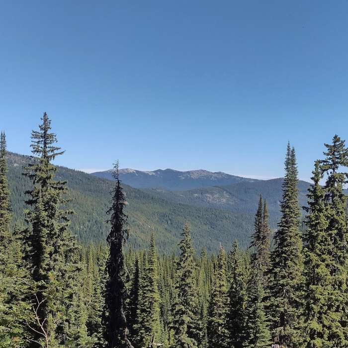 Mountains and forested valleys into the distance, are seen to the north from the high switchbacks of Bottleneck Lake Trail. Near Bottleneck Lake Out-and-Back
