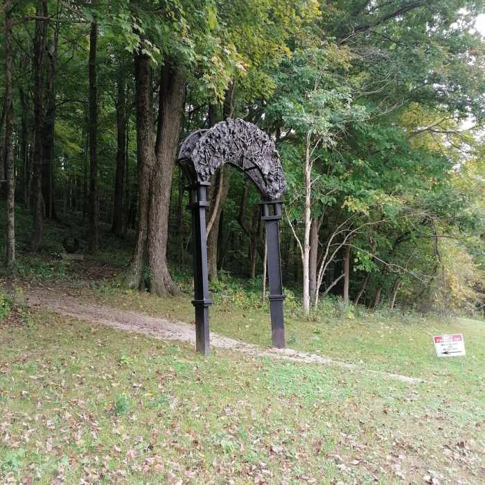 An impressive arch by artist Jack Gron. Not by the public parking lot, but close enough. GPS = 39.12152, -86.78441 Near Sculpture Trails Outdoor Museum