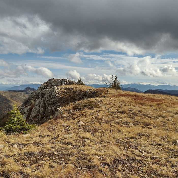Mount Pend Oreille summit block with scary cliffs on its north side. More of the Cabinet Mountains can be seen in the distance to the east. Near Mount Pend Oreille Out-and-Back