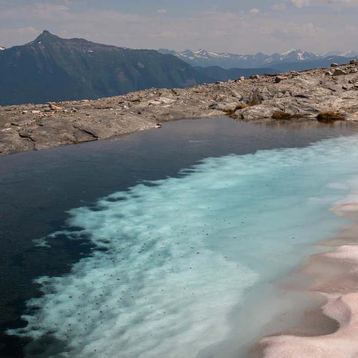 A snowfield melts into a small pool at the base of Begbie Glacier. Near Mount Begbie Trail to Begbie Glacier