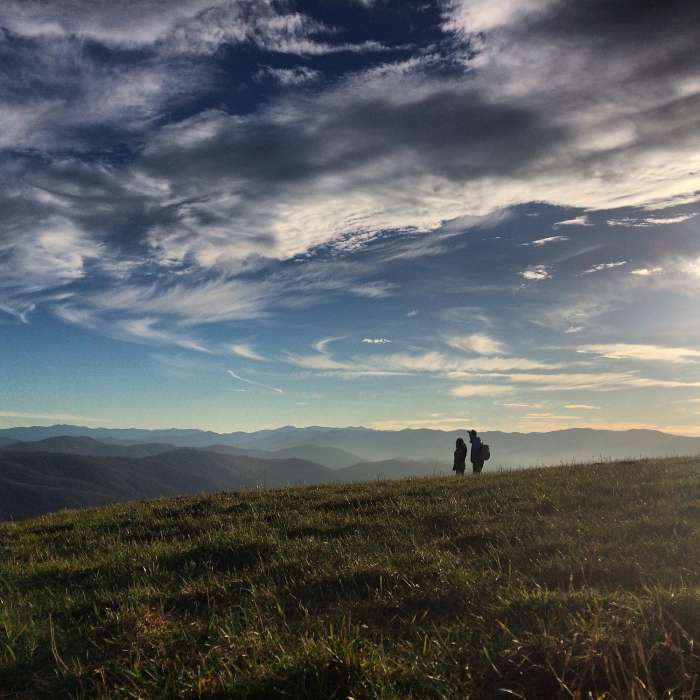 The Peoples Trail - A photo shot of a couple along the Appalachian Trail from atop Max Patch Mountain in Pisgah National Forest. There are many stunning views along the 2,200-mile east coast trail, but nothing quite like the panoramic scene of the Blue Ridge Mountains. Near Max Patch Short Loop