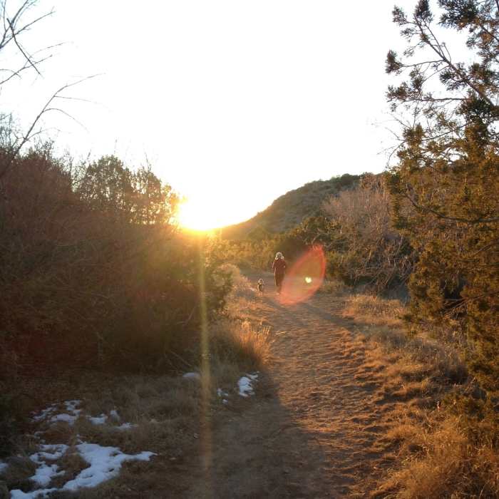 A woman and her dog head west from Bridal Veil Falls chasing the sunset. Near Fresnal Canyon Rails-to-Trails