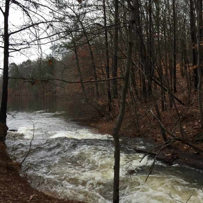 Water flows heavily from the creek into Stone Mountain Lake after a couple days of rain. Near Stone Mountain State Park Loop