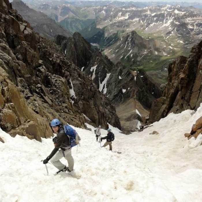 Hikers descending the gully, not far from the summit. The 13,500 ft saddle can be seen in the distance. Near Southwest Ridge of Mount Sneffels