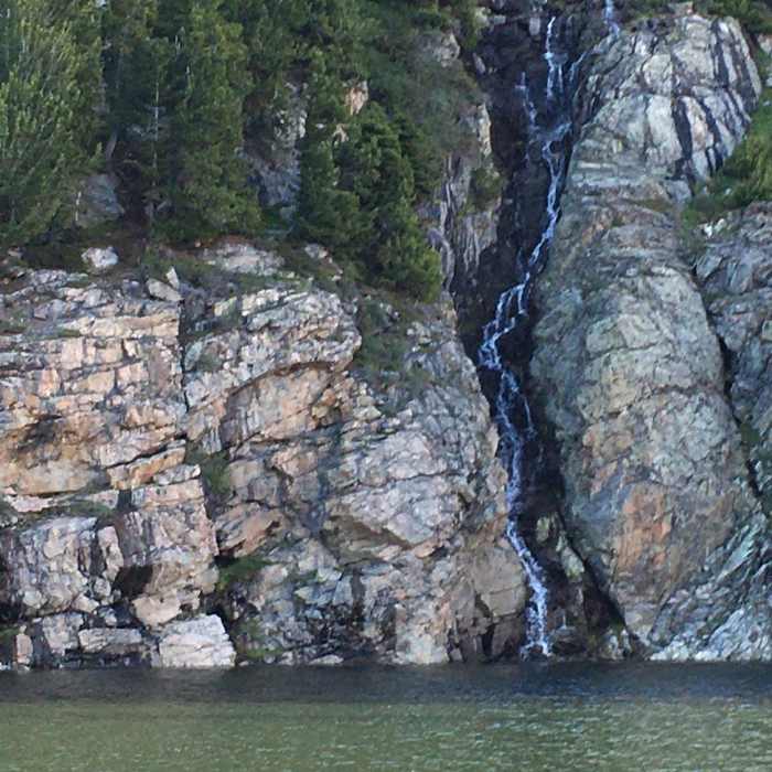 Looking over Jack Joe lake to stream going down face of rocks. Near Wind River Peak Trail