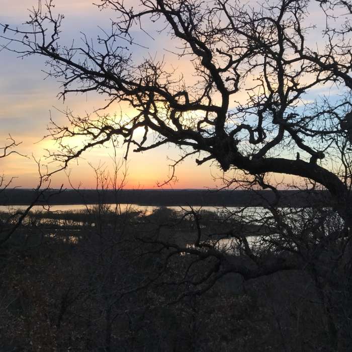 The sun rises over Lake Mineral Wells State Park from the Cross Timbers Black Trail. Near Cross Timbers Black Trail