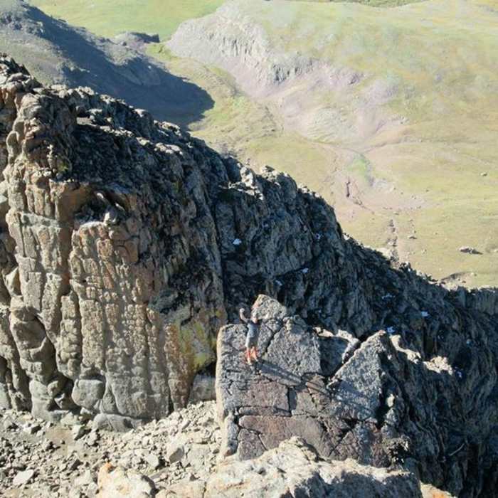 A hiker approaches the summit block. The technical formation behind him is not a part of this hike. There are many excellent scrambling options in this area. Have fun, but be careful! Near Wetterhorn Peak
