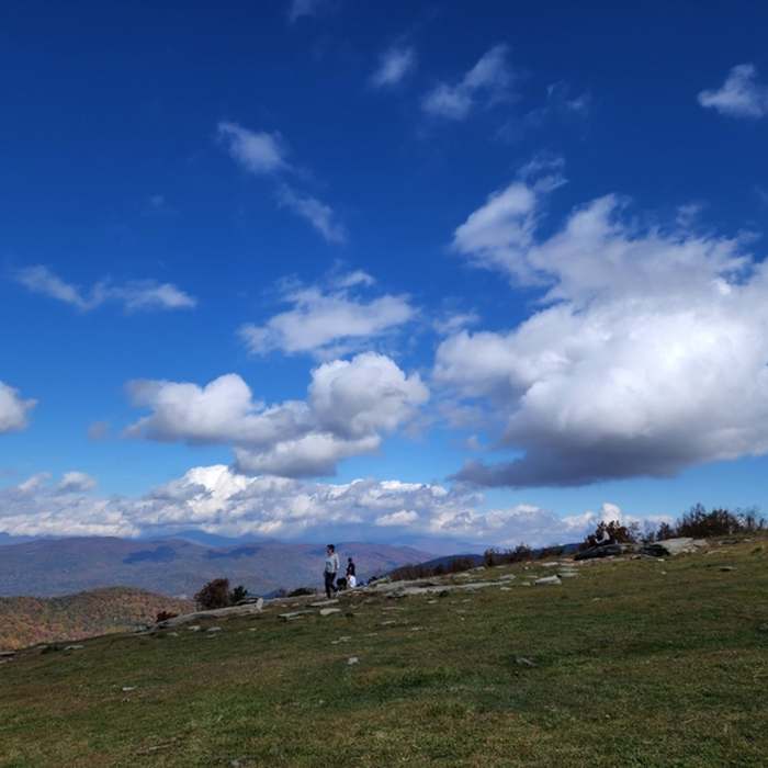 People on, and clouds over, Bearwallow Mountain. Near Bearwallow Mountain Loop