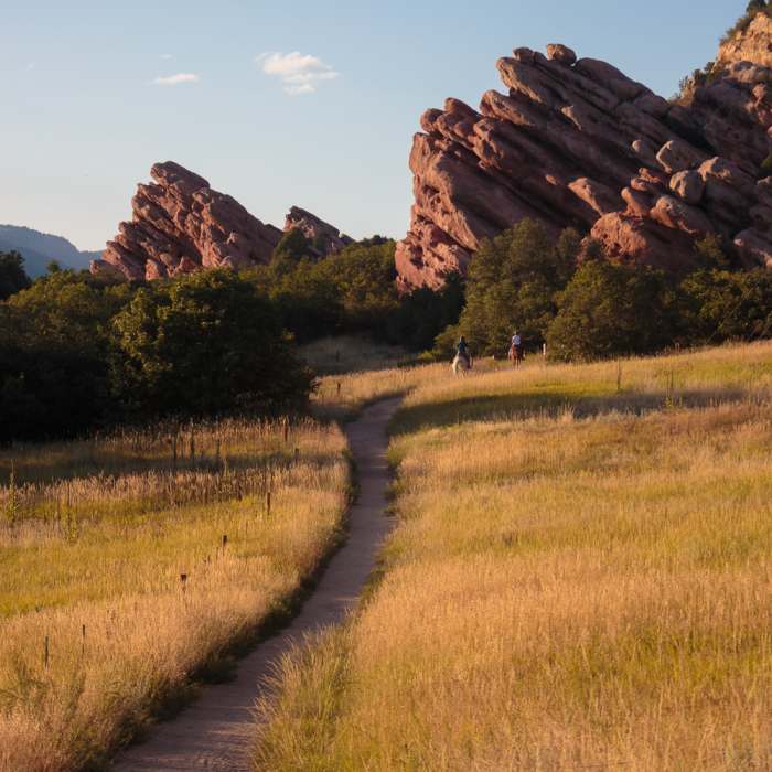 Horse riders and rock formations during golden hour Near Coyote Song Trail